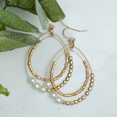 double layered hoop earrings with textured beading in gold and pearl white